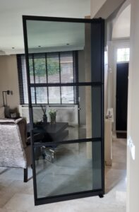 stalen trapleuning en taatsdeur met grijs flow glas by siebendesign.nl